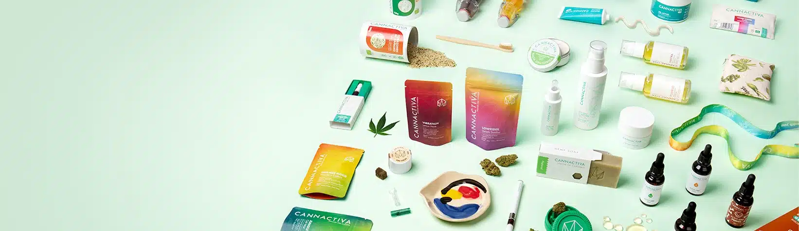 banner productos-canamo cannactiva multiproducto Flat lay de productos Cannactiva de CBD y cáñamo (aceites con gotero, cremas, cosmética y flores) sobre fondo verde menta.