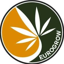 Logo Eurogrow circular Logo de Eurogrow en forma circular, con fondo verde oscuro y naranja, una hoja de cannabis blanca en el centro y el nombre “EUROGROW” en letras blancas alrededor del borde.