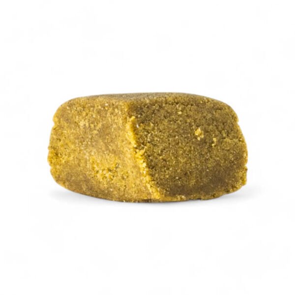 Tropicana cookies dry hash buenahierba Primer plano de Tropicana Cookies Dry Hash CBD de Buenahierba, mostrando la textura del hachís, fondo claro.
