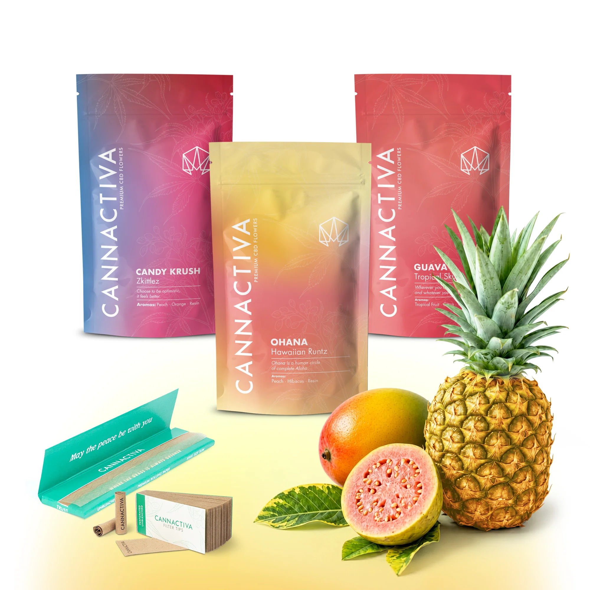 Flavour Pack Dulce Tropical de flores de CBD de Cannactiva Pack Dulce Tropical de Cannactiva con envases de Candy Krush, Ohana y Guava, junto a frutas tropicales y accesorios de la marca.